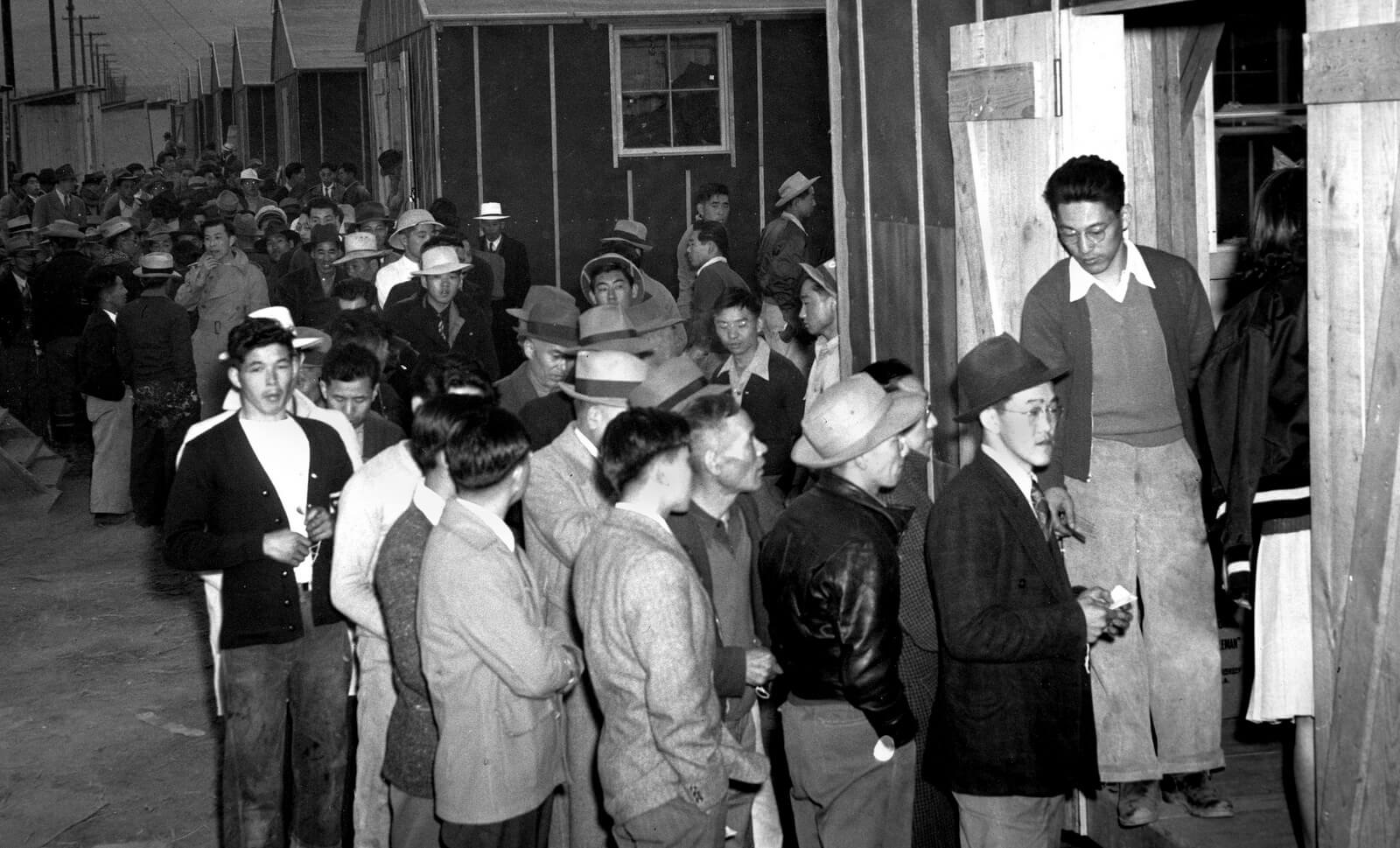 After being forced from the homes in Los Angeles by the U.S. Army, Japanese civilians wait in line for their assigned homes at an alien reception center in Manzanar, Calif. 120,000 Japanese-Americans were imprisoned during World War II. Photo | AP