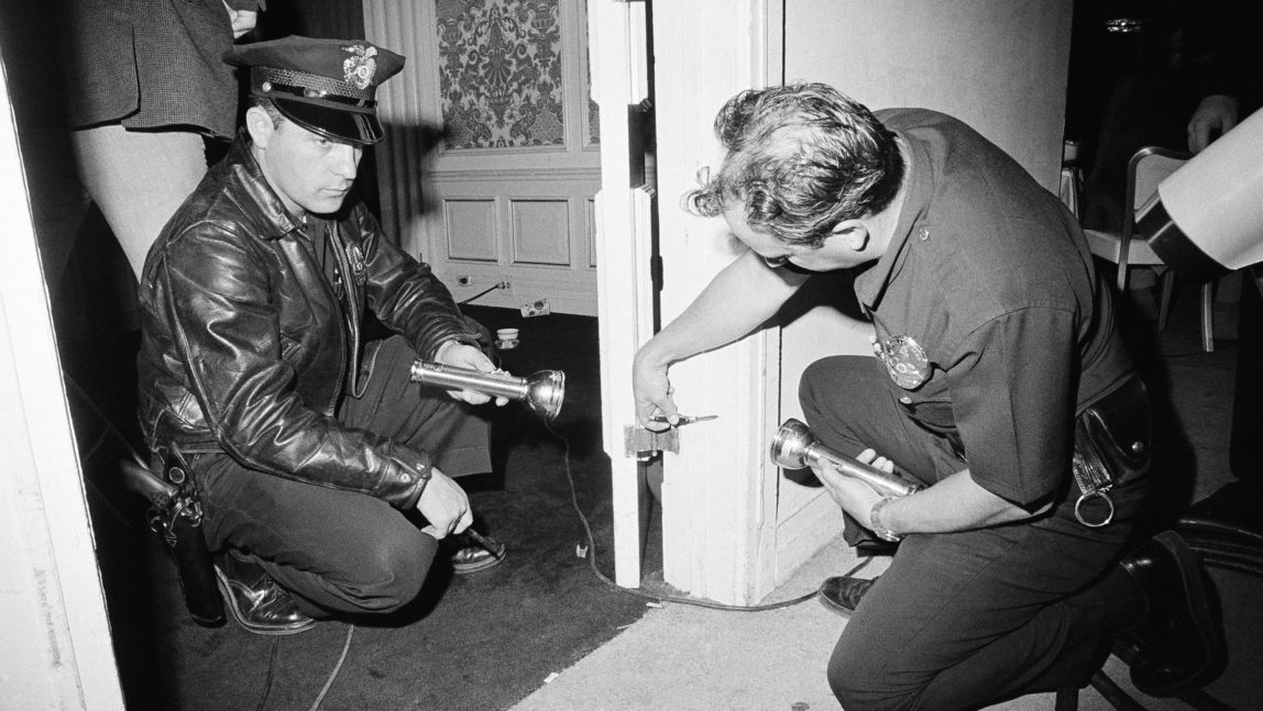 Charles Wright, a police technician, and officer Robert Rozzi inspects a bullet hole discoverd in a door frame in a kitchen corridor of the Ambassador hotel in Los Angeles near where Sen. Robert F. Kennedy was shot and critically wounded June 5, 1968. Bullet is still in the wood. Dick Strobel | AP