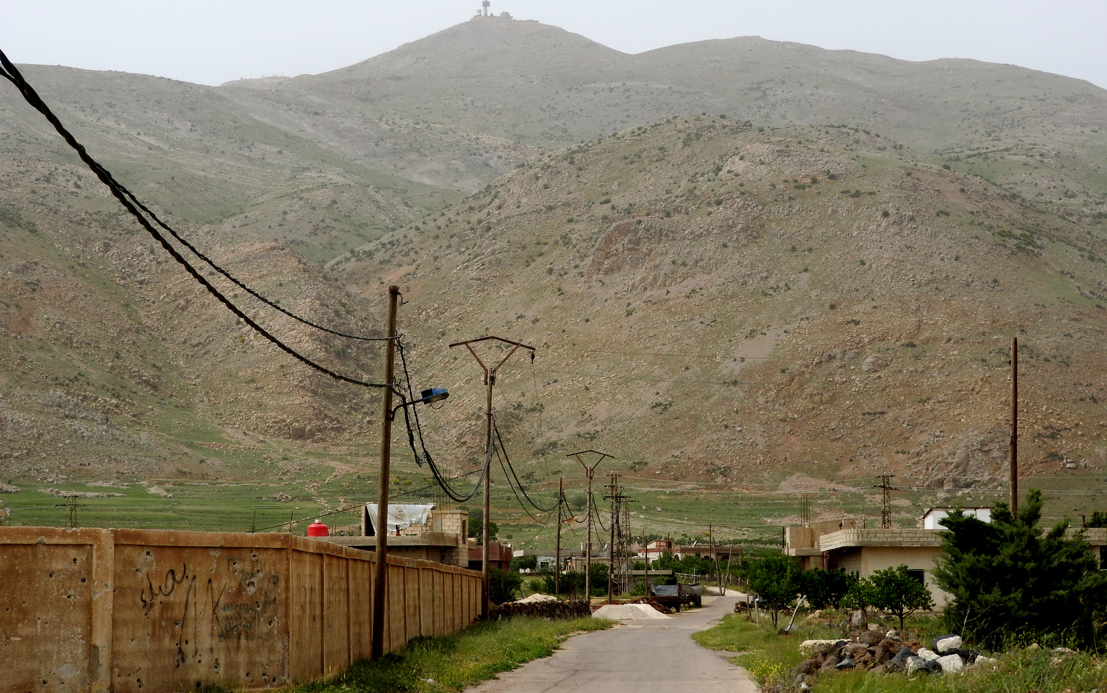 The road leading to the site of the deadly, Nov 2017 suicide car bomb. An Israeli observation post is visible atop in the mountain in the background. Eva Bartlett | MintPress News