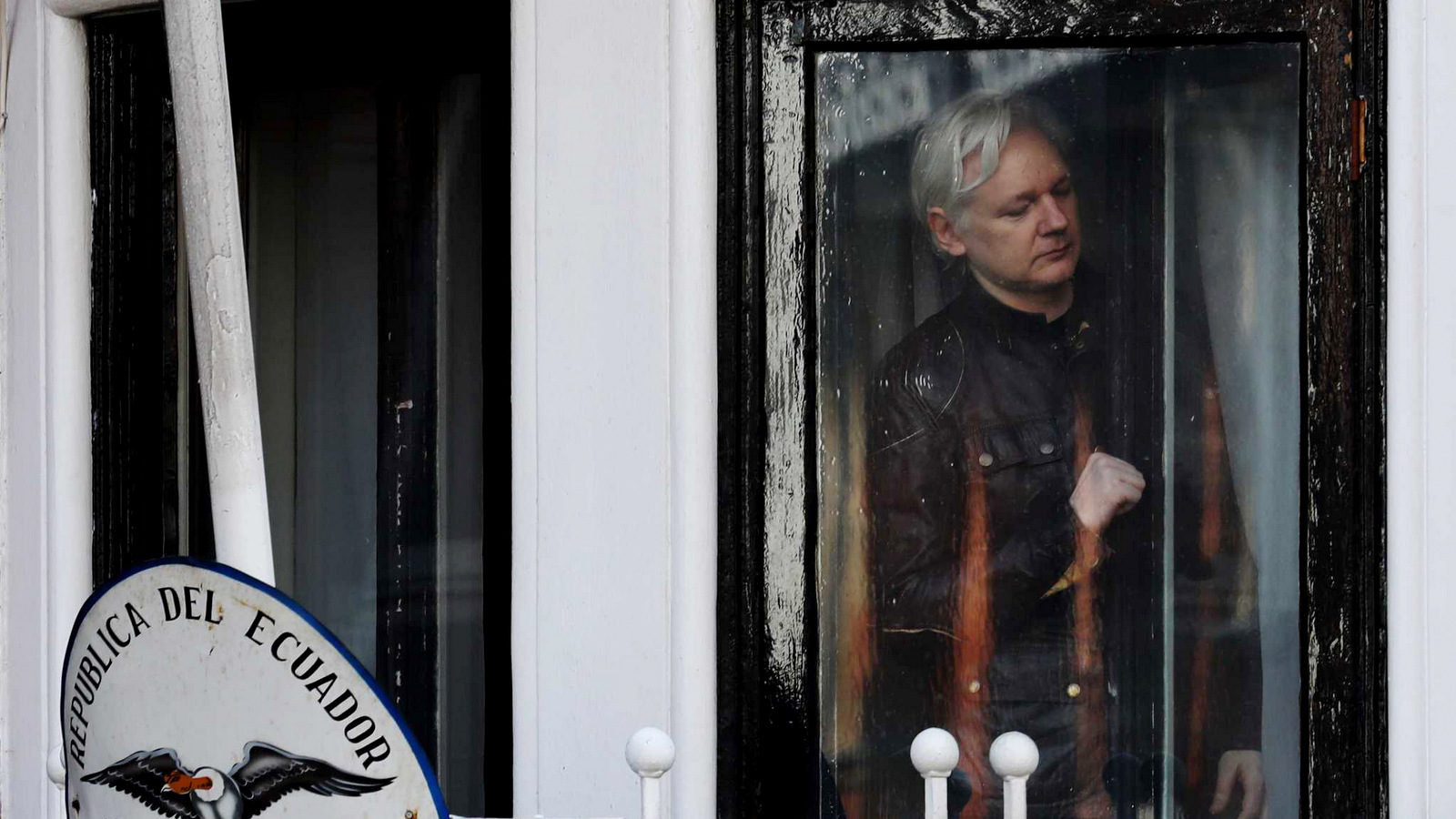 WikiLeaks founder Julian Assange looks out the window of the Ecuadoran embassy in London, where he was been confined for extradition to the United States. Luke MacGregor | Bloomberg