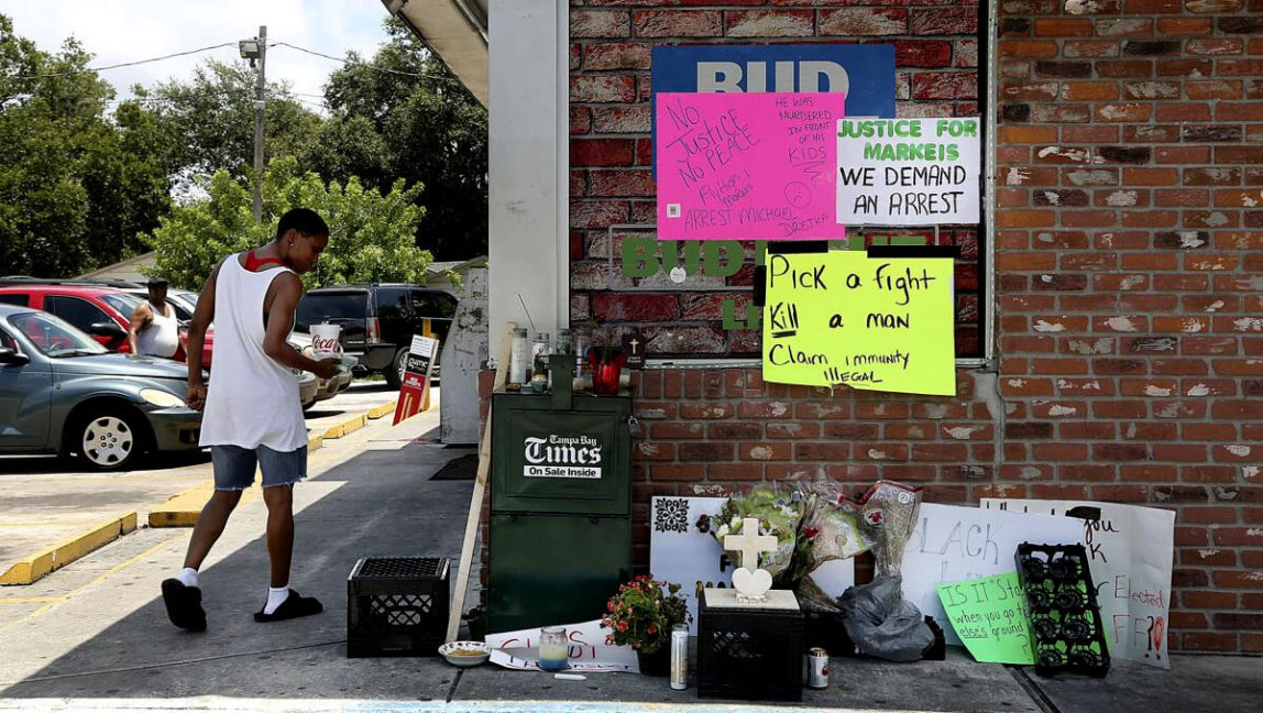 Tempe Louis, of Clearwater, pauses to observe a memorial on the side of the Circle A Food Mart, in Clearwater, Fla on July 24, 2018. Douglas R. Clifford | Tampa Bay Times via AP