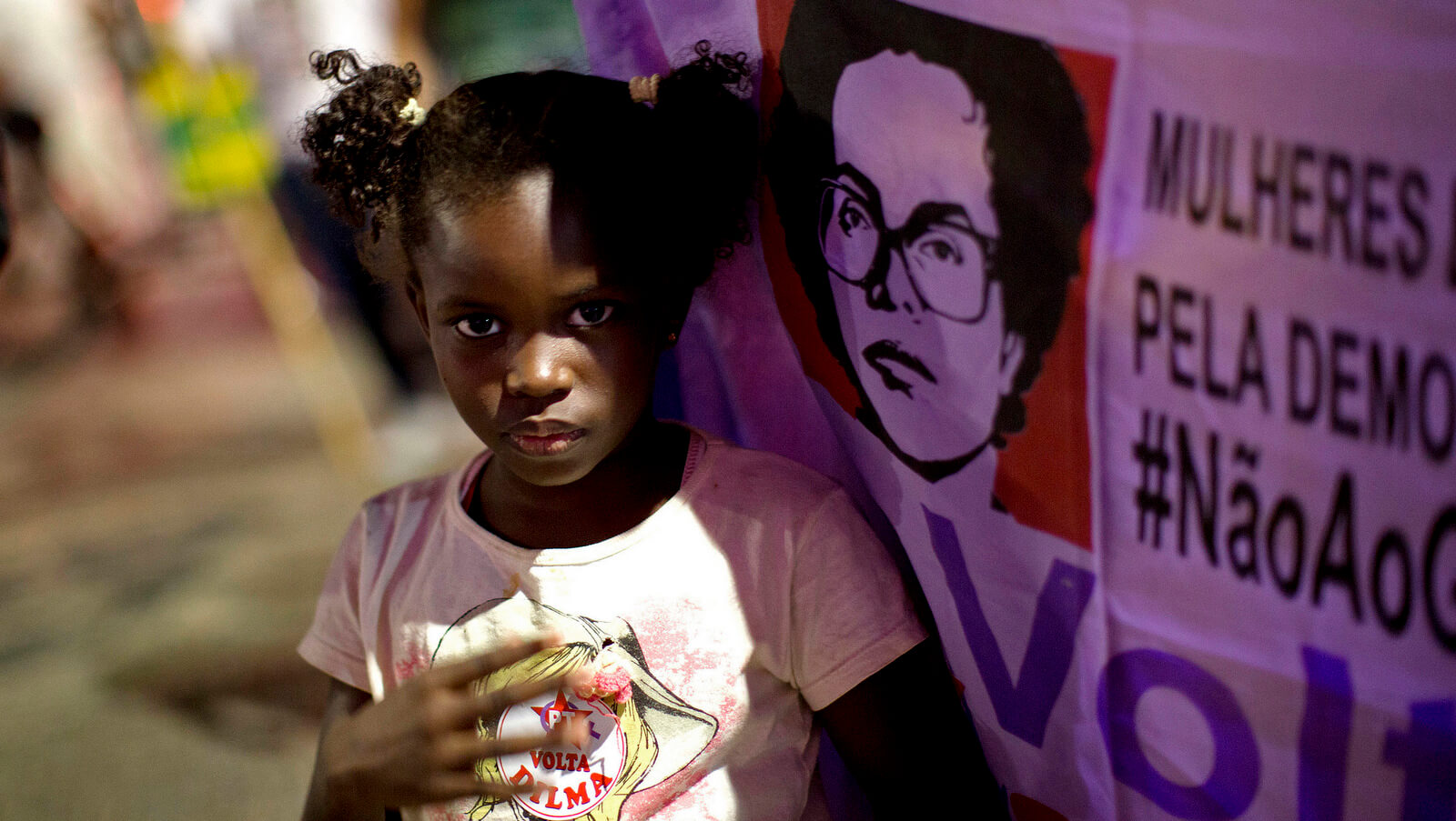 Una niña se encuentra junto a un letrero que muestra una imagen de la derrocada presidenta Dilma Rousseff durante una protesta contra el actual presidente de Brasil, Michel Temer, en Río de Janeiro, Brasil, el 2 de agosto de 2017. Silvia Izquierdo | AP