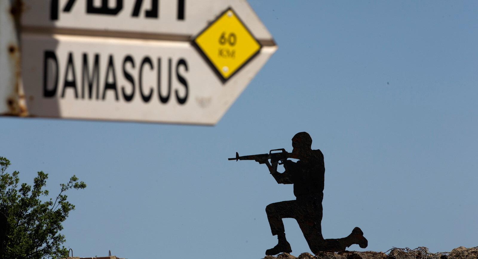 A mock road sign for Damascus, the capital of Syria, and a cutout of a soldier, are displayed in an old outpost in the Israeli controlled Golan Heights near the border with Syria, May 10, 2018. Ariel Schali | AP