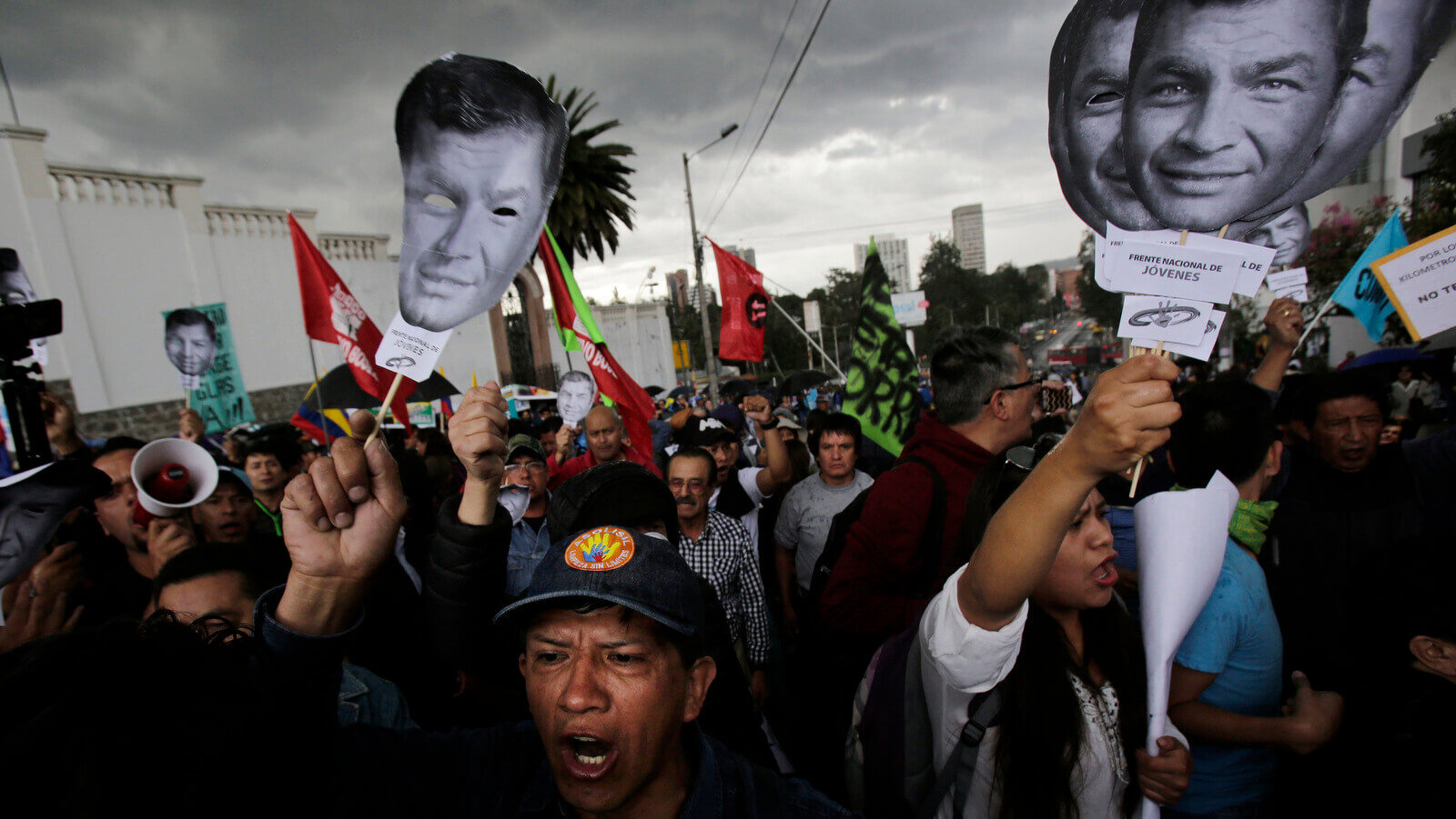 Supporters of Ecuador's former President Rafael Correa hold up images of his face as they protest an attempt to prosecute him, outside the National Assembly in Quito, Ecuador, June 14, 2018. Dolores Ochoa | AP