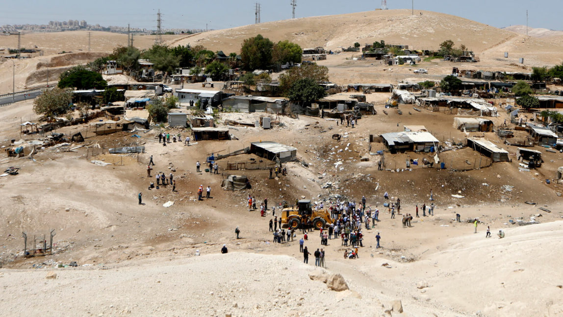 Protesters surround a bulldozer in the Palestinian village of Khan al-Ahmar, July 4, 2018. Israeli police scuffled with with people protesting the demolition of the village which is Israel says is illegal due to a lack of building permits, despite being on Palestinian land in the West Bank. Majdi Mohammed | AP