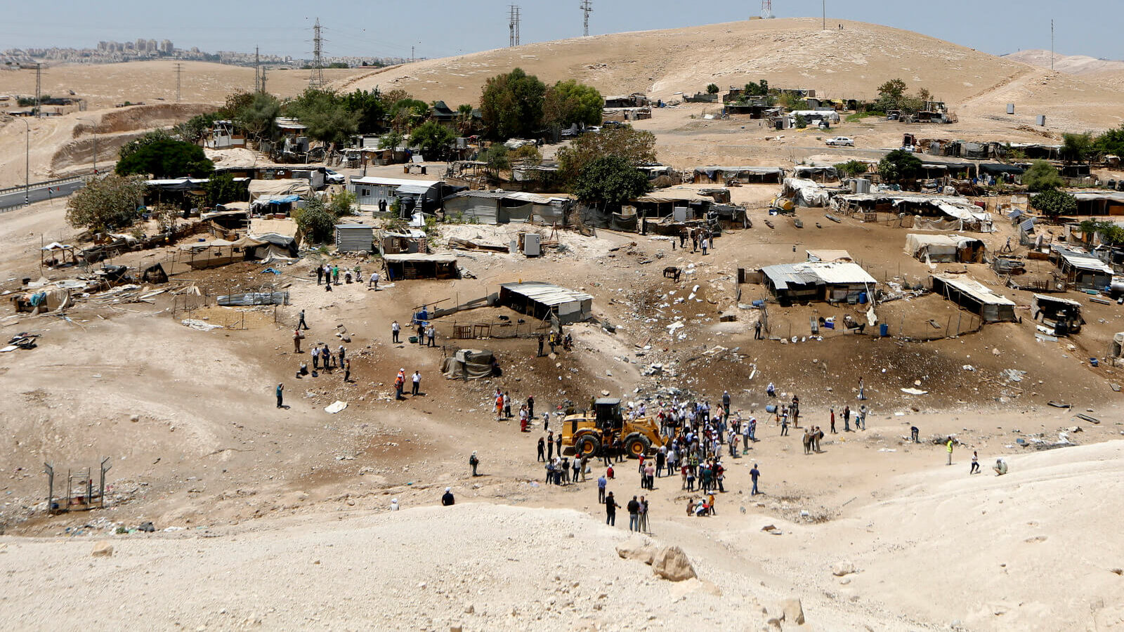 Protesters surround a bulldozer in the Palestinian village of Khan al-Ahmar, July 4, 2018. Israeli police scuffled with with people protesting the demolition of the village which is Israel says is illegal due to a lack of building permits, despite being on Palestinian land in the West Bank. Majdi Mohammed | AP