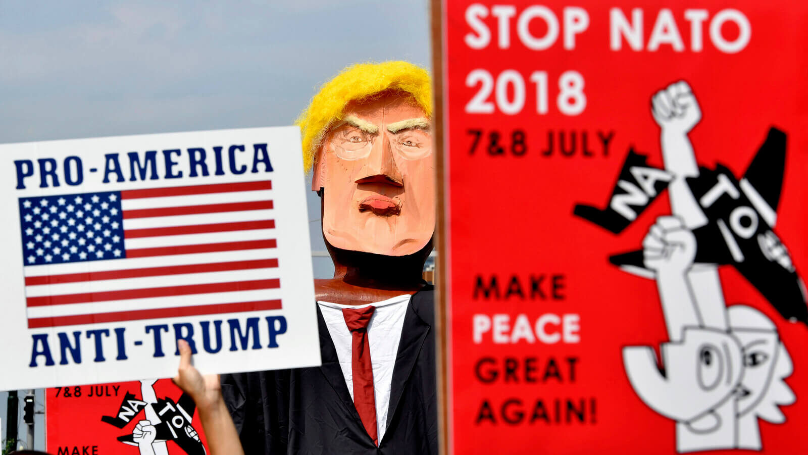Protestors march next to giant puppet of U.S. President Donald Trump during a demonstration in Brussels, Saturday, July 7, 2018. Europeans are protesting U.S. President Donald Trump's appearance at a NATO summit, marching through Brussels to plead for less military spending and more public money for schools and clean energy. Geert Vanden Wijngaert | AP