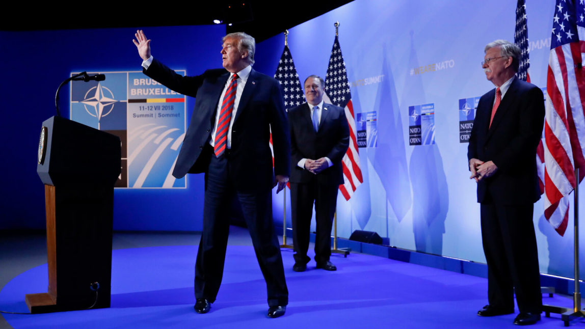 Donald Trump waves as he walks off stage after holding a news conference before his departure at the NATO Summit in Brussels, Belgium, July 12, 2018. With Trump are Secretary of State Mike Pompeo, center, and National security adviser John Bolton, right. Pablo Martinez Monsivais | AP