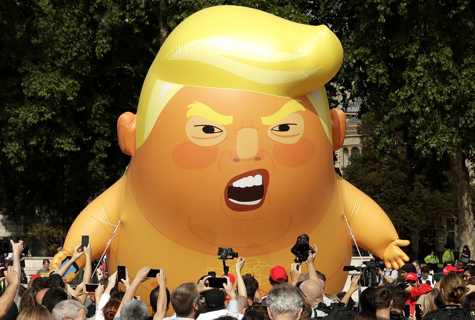 A six-meter high cartoon baby blimp of U.S. President Donald Trump is flown as a protest against his visit, in Parliament Square in London, England, July 13, 2018. Matt Dunham | AP