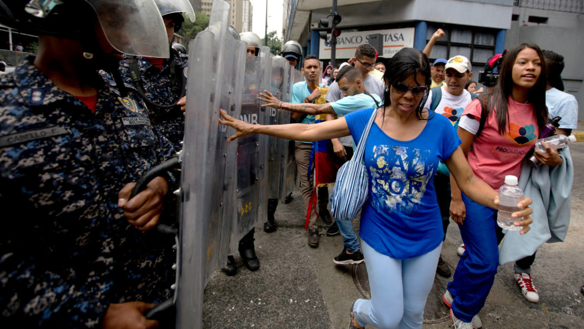 Demonstrators push police's shields as they protest Venezuela's President Nicolas Maduro near the attorney generals office in Caracas, Venezuela, July 18, 2018. The previous night, former presidential candidate and opposition leader Henrique Capriles called on the country's political forces to reorganize in order to cope with the South American country's hyperinflation, and lack of food and medicine. Fernando Llano | AP