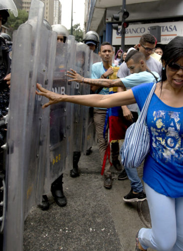 Demonstrators push police's shields as they protest Venezuela's President Nicolas Maduro near the attorney generals office in Caracas, Venezuela, July 18, 2018. The previous night, former presidential candidate and opposition leader Henrique Capriles called on the country's political forces to reorganize in order to cope with the South American country's hyperinflation, and lack of food and medicine. Fernando Llano | AP