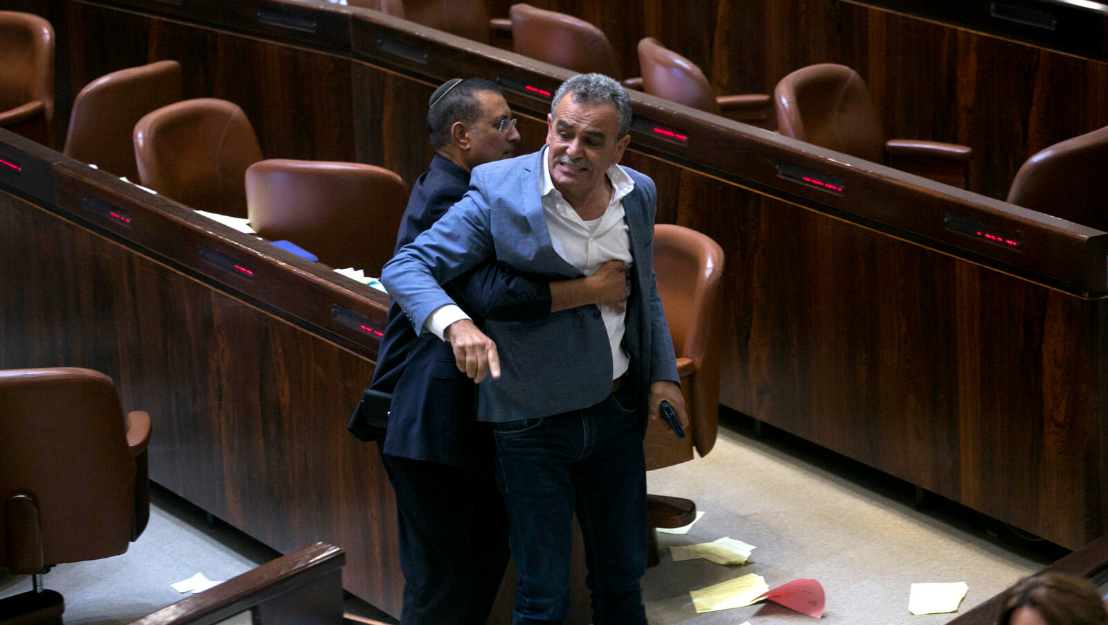 A Knesset usher removes Jamal Zahalka, an Israeli Arab member of the Knesset protesting the passage of a contentious bill, during a Knesset session in Jerusalem, July 19, 2018. Olivier Fitoussi | AP