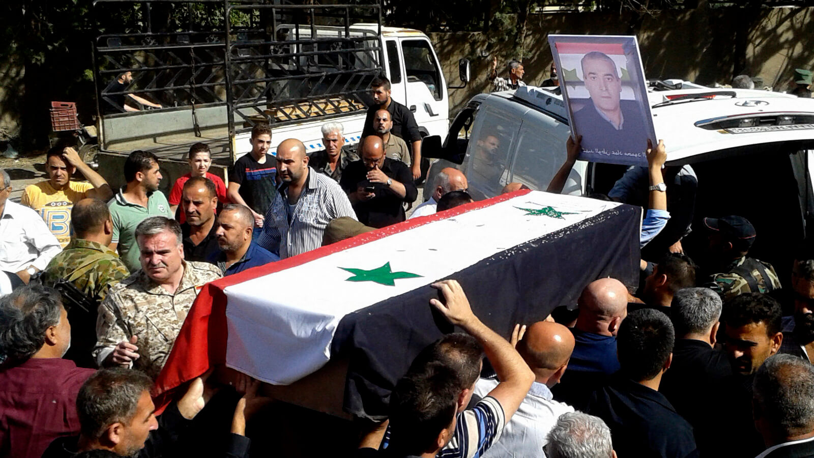 Mourners carry a coffin of more than 200 people who killed a day earlier by a series of suicide bombings launched by ISIS in Sweida, Syria, July 26, 2018. A government official says the death toll from coordinated attacks on a usually peaceful city and its countryside has climbed to 216, in the worst violence to hit the area since the country's conflict began. SANA | AP