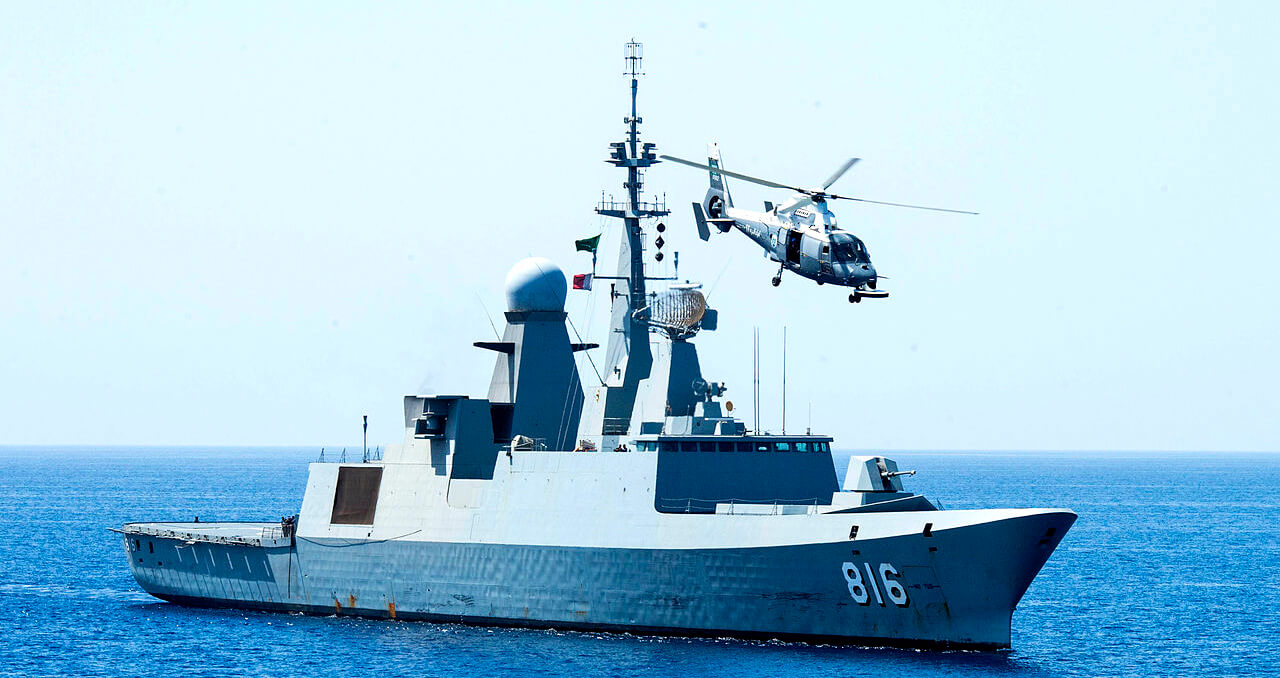 The Royal Saudi Navy frigate Al Dammam (816) maneuvers into position, with its embarked AS565 SA Dauphin helicopter circling overhead, during exercise "Eager Lion 2014" in the Gulf of Aden. U.S. Navy photo
