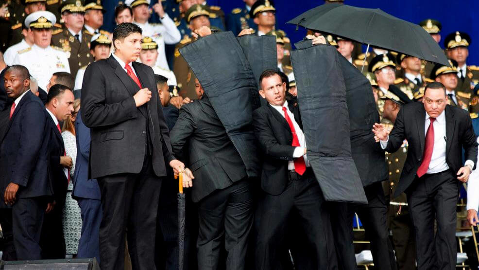 In this photo released by China's Xinhua News Agency, security personnel surround Venezuela's President Nicolas Maduro during an incident as he was giving a speech in Caracas, Venezuela, Aug. 4, 2018. Drones armed with explosives detonated near Venezuelan President Nicolas Maduro as he gave a speech to hundreds of soldiers in Caracas on Saturday but Maduro was unharmed. Xinhua via AP