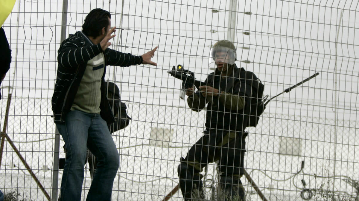 Un soldado israelí apunta con su rifle a un palestino desarmado durante una protesta contra el muro del apartheid de Israel en la aldea palestina de Bilin, cerca de Ramallah. madi mohamed | punto de acceso