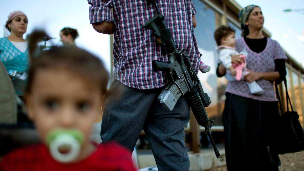 A Jewish man carries a rifle at a protest against Palestinian statehood in the Jewish-only settlement of Kiryat Arba, near the Palestinian town of Hebron. Bernat Armangue | AP