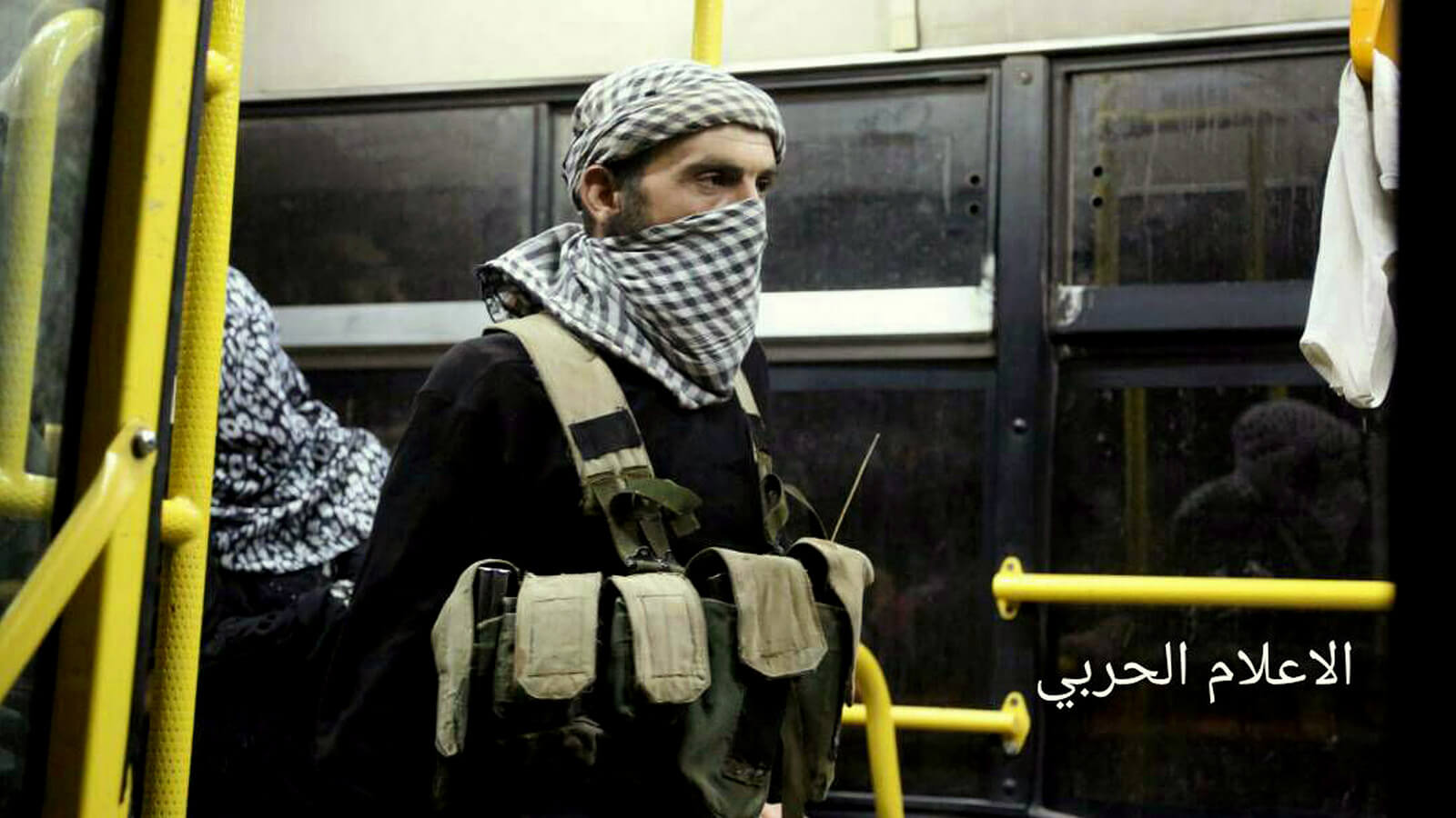 An al-Qaeda-linked militant standing in a bus, after being evacuated from the town of Arsal, near the Syrian border, in northeast Lebanon route to the rebel-held Idlib province in northwest Syria. Syrian Central Military Media via AP