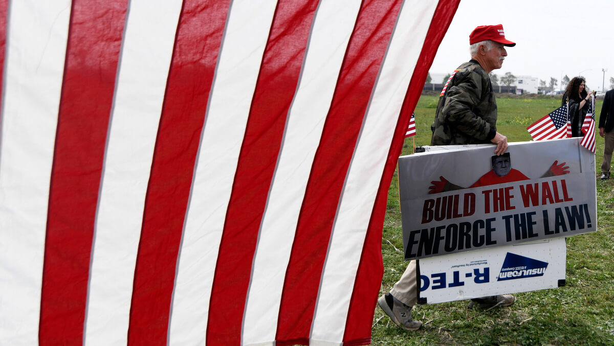 A Trump supporter walks at to a Trump rally March 13, 2018, in San Diego. Kyusung Gong | AP