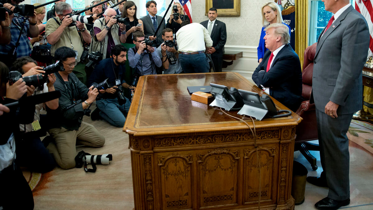 President Donald Trump speaks to members of the media in the Oval Office of the White House in Washington, June 20, 2018. Standing with Trump are Homeland Security Secretary Kirstjen Nielsen and Vice President Mike Pence. Pablo Martinez Monsivais | AP