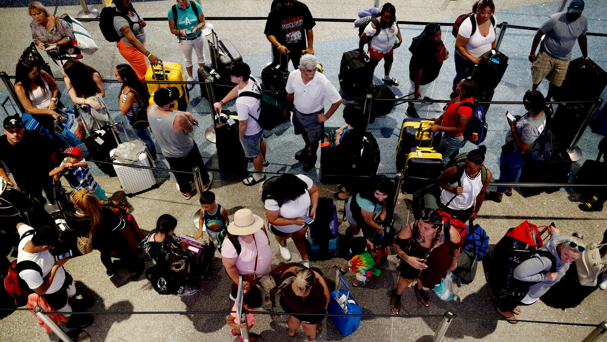 People wait in line to check in at McCarran International Airport in Las Vegas. John Locher | AP