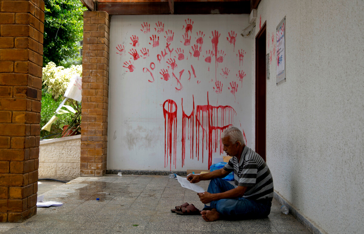 A Palestinian employee sits during a protest at the United Nations agency for Palestinian refugees (UNRWA) headquarters in Gaza City, July 25, 2018. UNWRA staff are protesting the agency's decision to fire dozens of Palestinian staff in Gaza in the Gaza Strip. Khalil Hamra | AP