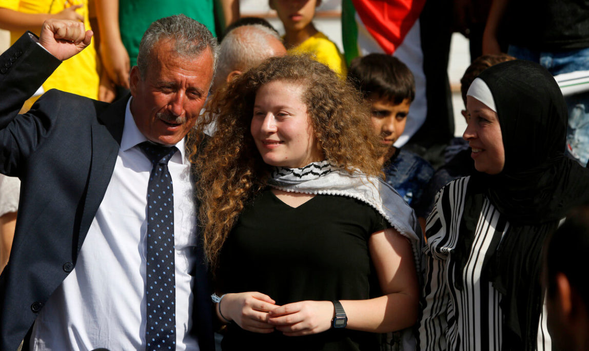Ahed Tamimi stans between her father Bassam and mother Nariman during a press conference on the outskirts of the West Bank village of Nabi Saleh near the West Bank city of Ramallah, July 29, 2018. Palestinian protest icon Ahed Tamimi and her mother Nariman returned home to a hero's welcome in her West Bank village on Sunday after Israel released the 17-year-old from prison at the end of her eight-month sentence for slapping an Israeli soldier .Majdi Mohammed | AP