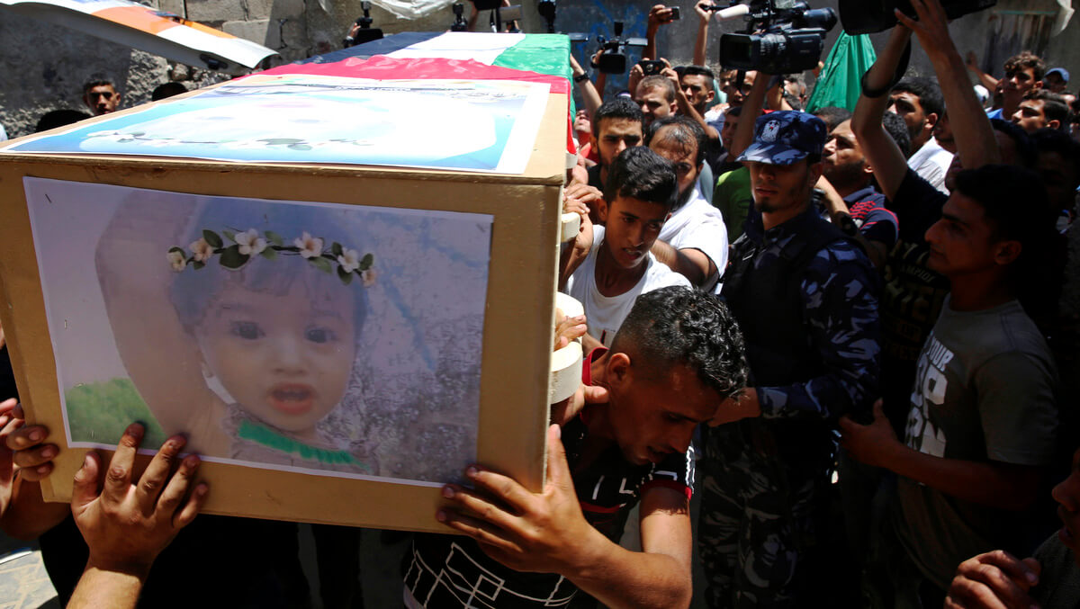 Palestinian mourners carry the coffin of 23-year-old pregnant mother Enas Khamash and her daughter Bayan, whose picture is on the coffin, during their funeral in Deir el-Balah, central Gaza Strip, Aug. 9, 2018. Khamash and her daughter were killed in an Israeli airstrike on Gaza. Adel Hana | AP