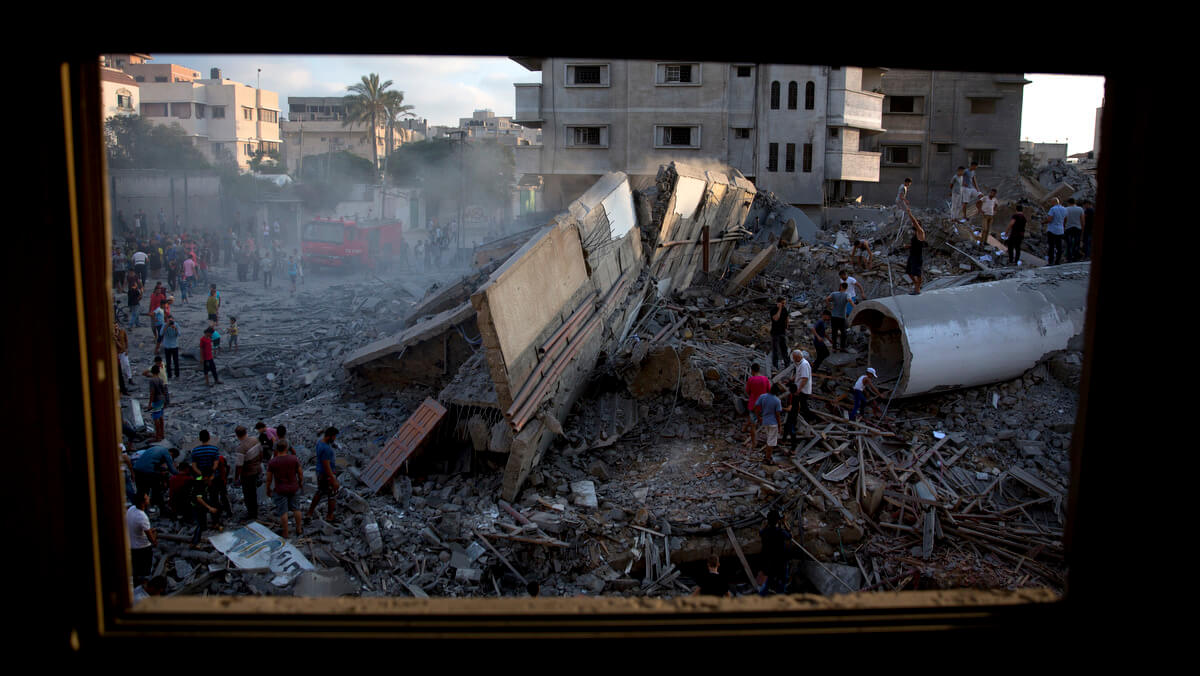 Palestinians inspect the Said al-Mis'hal cultural center after it was hit destroyed by an Israeli airstrike in Gaza City, Aug. 9, 2018. Khalil Hamra | AP