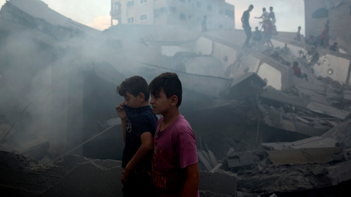 Palestinian children near the wreckage of the Said al-Mis'hal cultural center in the Shati refugee camp after it was hit by an Israeli airstrike in Gaza City, Aug. 9, 2018. Khalil Hamra | AP