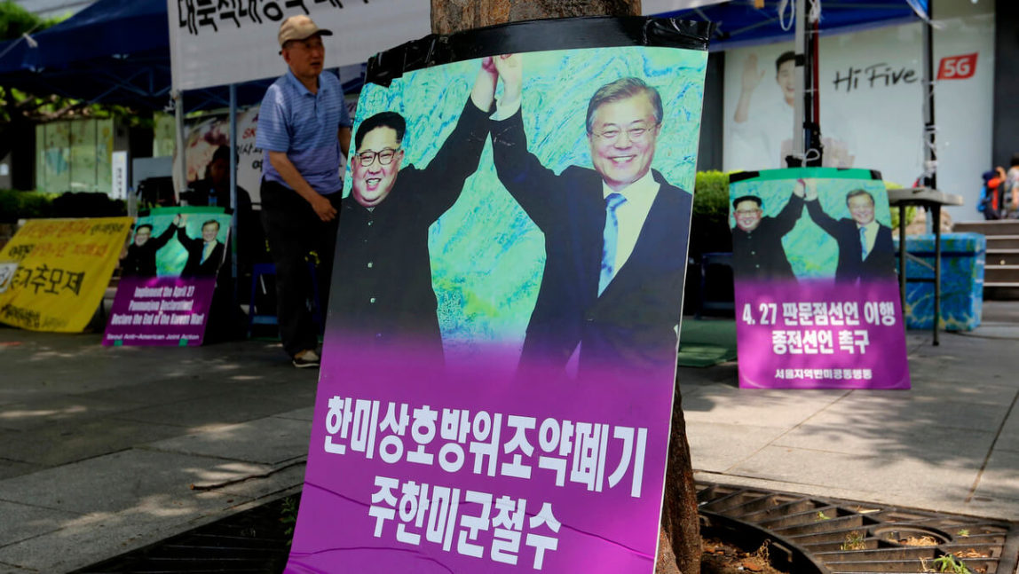 Photos showing North Korean leader Kim Jong Un, left, and South Korea President Moon Jae-in are displayed to demand withdrawal of U.S. troops from Korean Peninsula near the U.S. Embassy in Seoul, South Korea, Aug. 13, 2018. Ahn Young-joon | AP