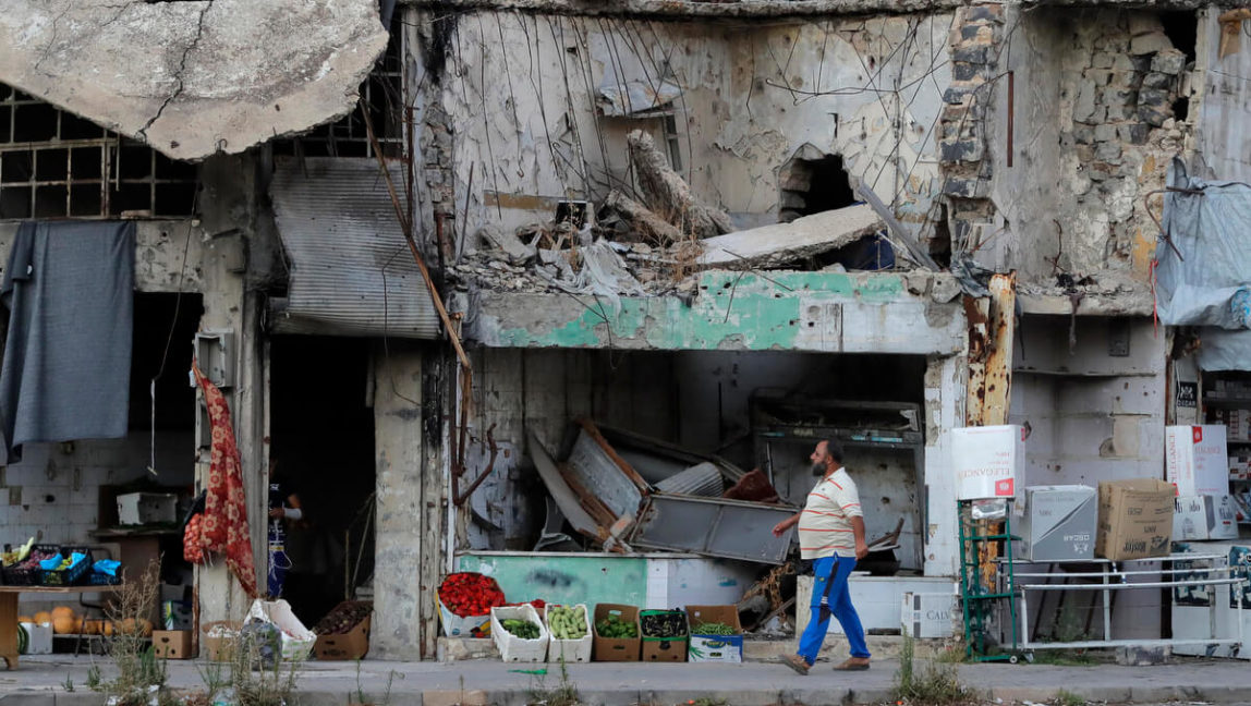 A man walks next to damaged buildings in the old town of Homs, Syria, Aug. 15, 2018. The Russian Defense Ministry said it is coordinating efforts to help Syrian refugees return home and rebuild the country's infrastructure destroyed by the civil war. Sergei Grits | AP