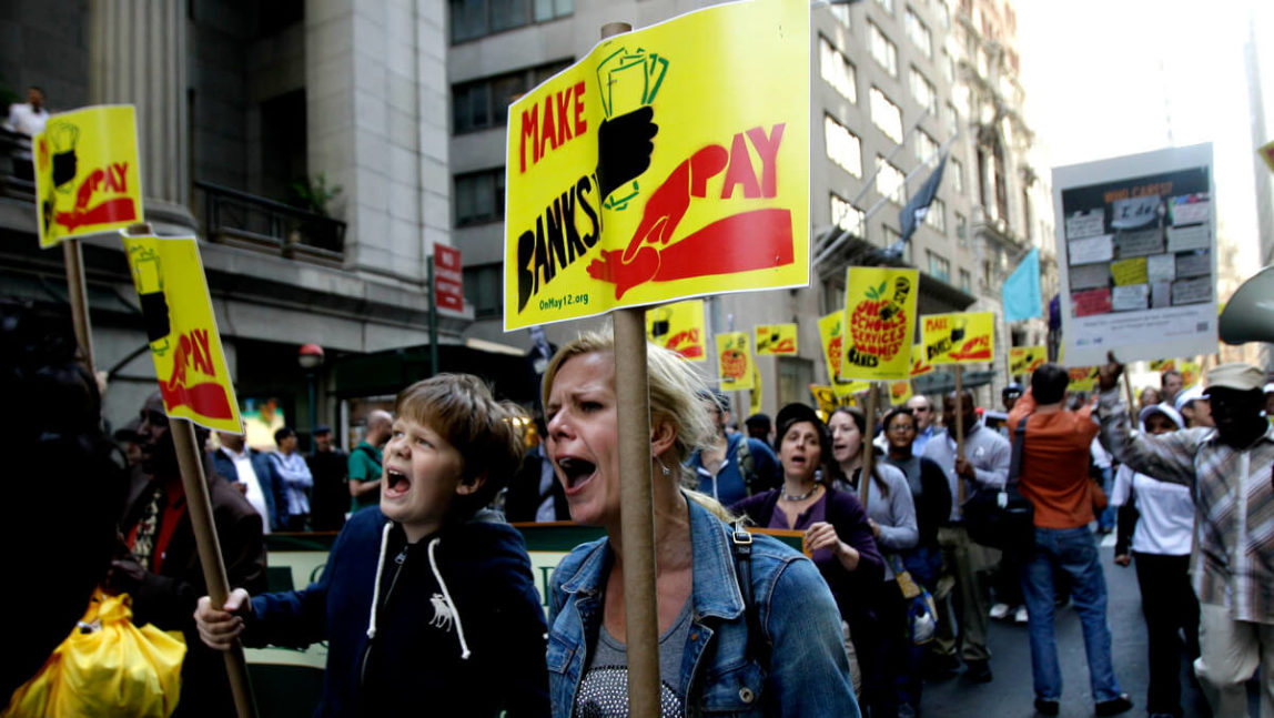 Protestors march down Wall Street to call attention to big bank bailouts and cuts in jobs and education in New York, May 12, 2011. Kathy Willens | AP