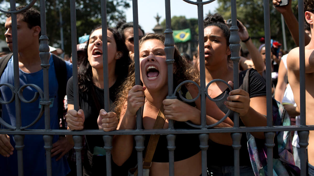 Students and National Museum employees protest outside the institution after it was gutted by an overnight fire in Rio de Janeiro, Brazil, Sept. 3, 2018. Silvia Izquierdo | AP