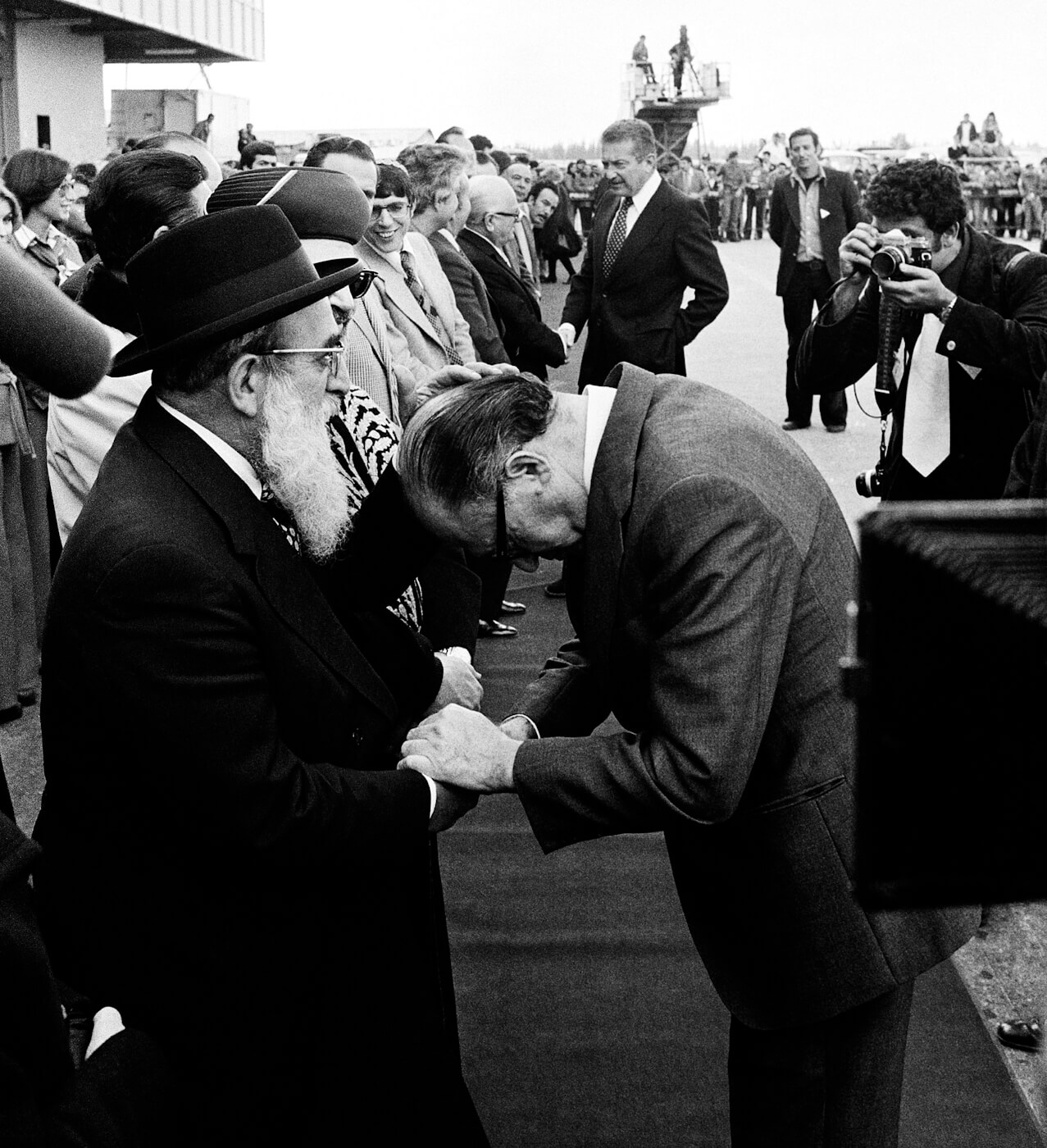Begin, right, bows his head to receive a blessing from Shlomo Goren in 1977 at Ben-Gurion Airport. Max Nash | AP