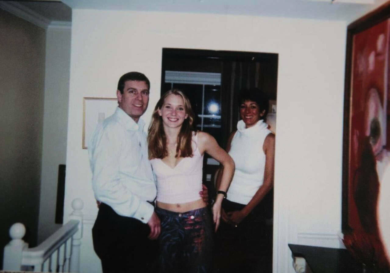 This undated photo released by Virginia Giuffre shows Prince Andrew posing with a young Giuffre, Ghislaine Maxwell is shown standing in the background
