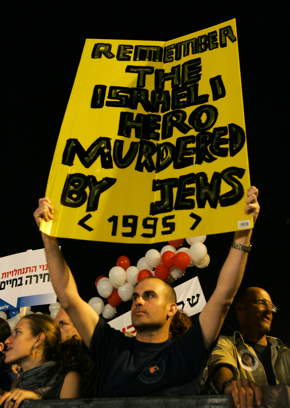 An Israeli holds a poster during a commemoration for slain Israeli Prime Minister Yitzhak Rabin in Tel Aviv. Peter Dejong | AP