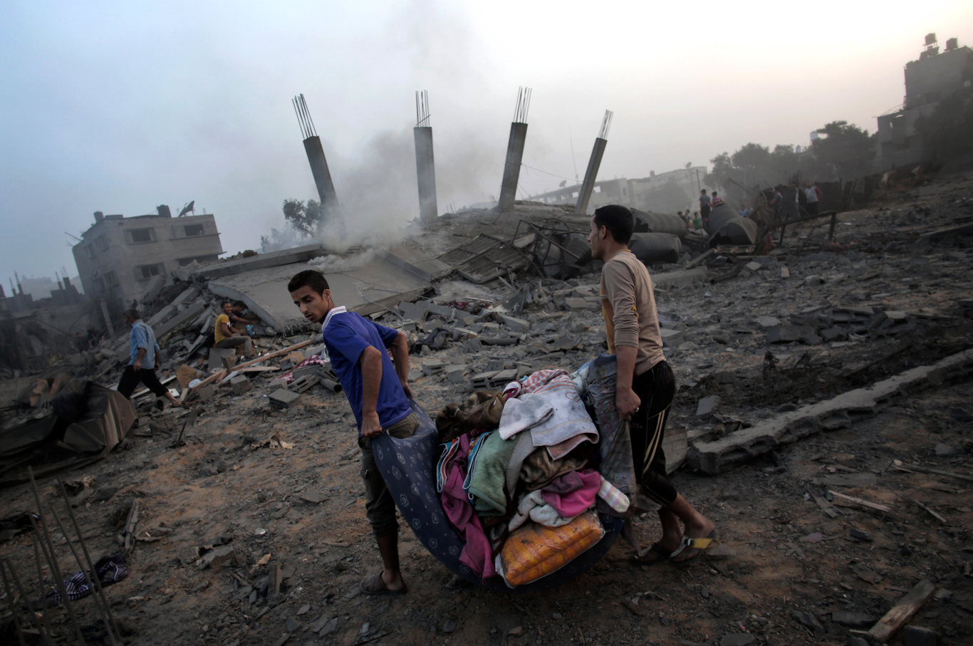 Palestinians salvage what they can from the rubble of a home destroyed by an overnight Israeli airstrike in Gaza, July 8, 2014. Khalil Hamra | AP