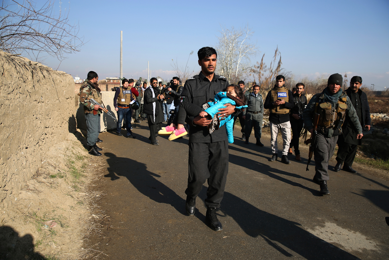 A police officer carries his injured daughter after an attack near a U.S. Air Base In Parwan province of Kabul, Afghanistan, Dec. 11, 2019. Rahmat Gul | AP