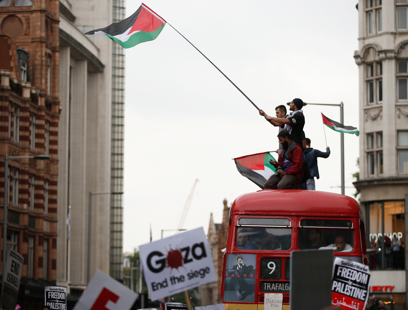 Demonstrators stand on top of London Bus during a protest near the Israeli embassy over its bombing of Gaza, July 11, 2014. Alastair Grant | AP