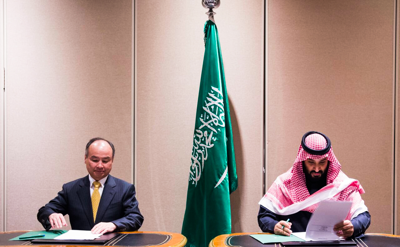 Masayoshi Son, left, signs a deal related to the Vision Fund with Bin Salman in March 2018. Photo | SPA
