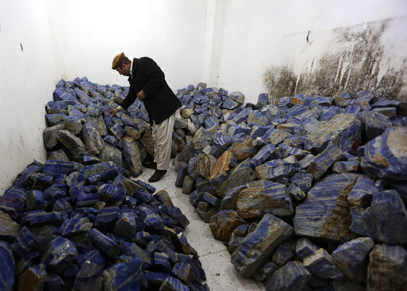 一名阿富汗商人在他位于喀布尔市的商店里检查青金石，这是该国丰富的矿产资源的重要组成部分。 Rahmat Gul | 美联社