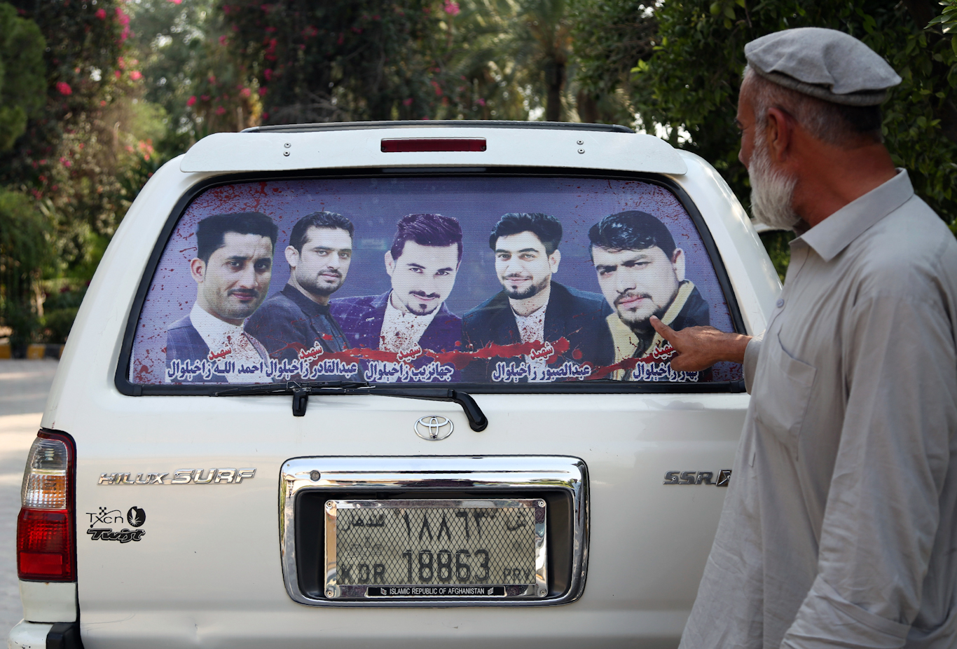 An Afghan man shows pictures of four brothers on the back of his car killed in a raid by the CIA-trained Unit 02 in Jalalabad, Oct. 1, 2019. Rahmat Gul | AP