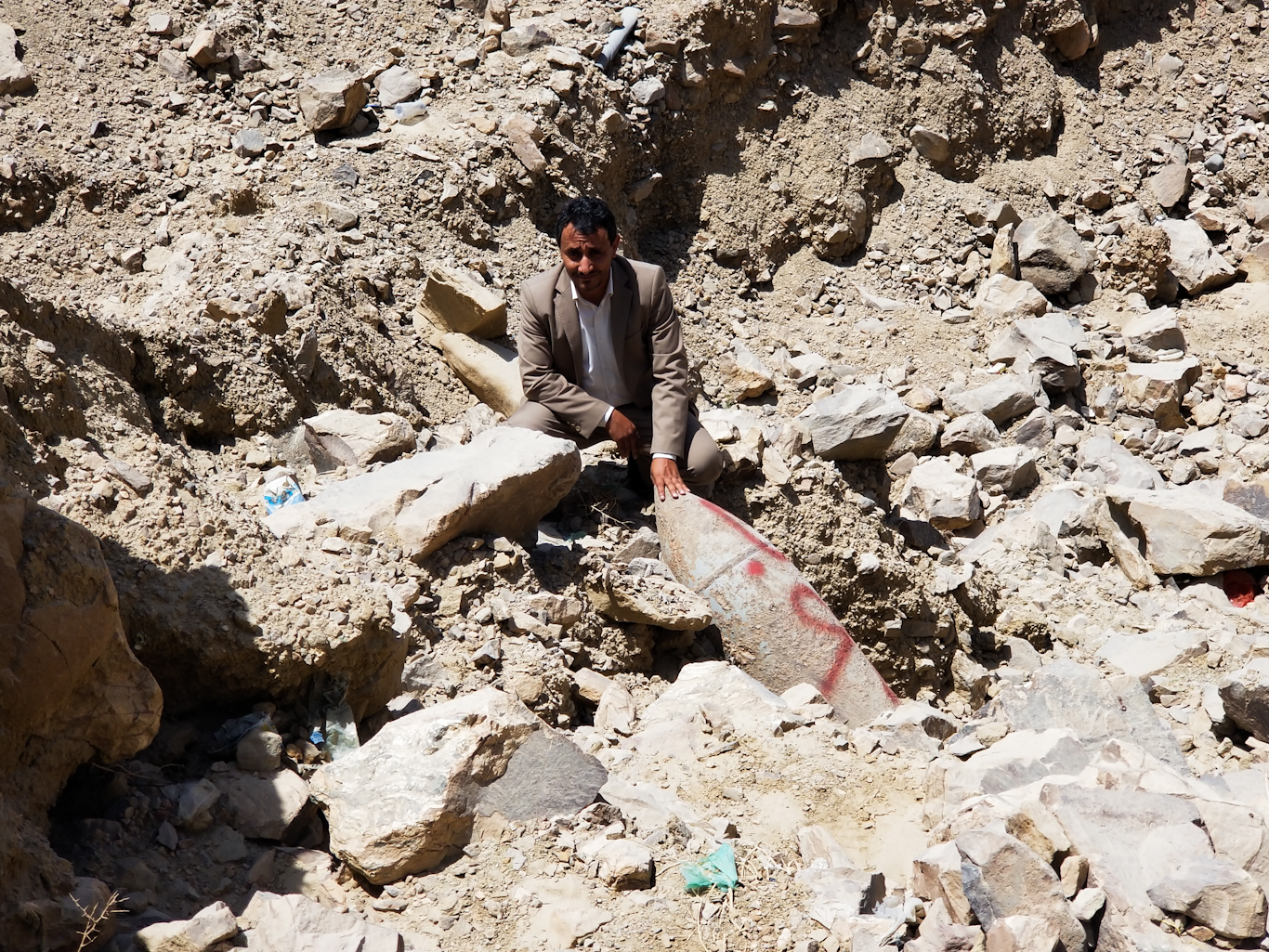 Man poses next to unexploded ordinance