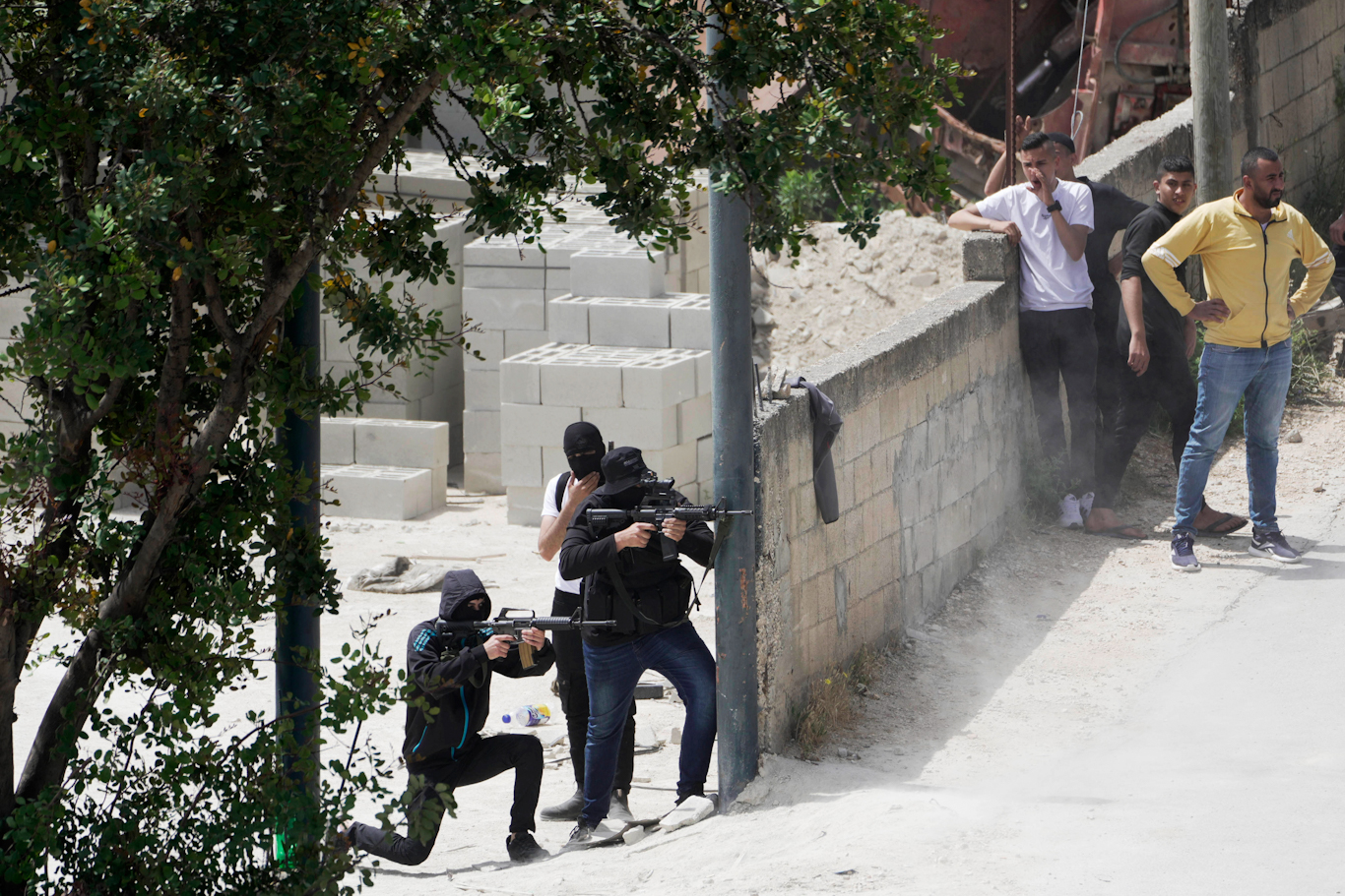Palestinian youth aim weapons