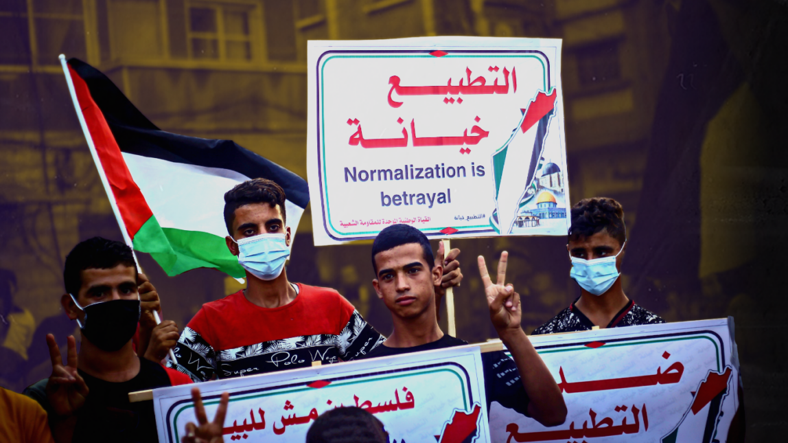 A protester holds a placard that says Normalization is betrayal during the demonstration. Palestinians protest against the Israeli normalization agreement with the UAE and Bahrain in Khan Yunis, in the southern Gaza Strip hours before the signing ceremony at the White House. (Photo by Yousef Masoud / SOPA Images/Sipa USA)(Sipa via AP Images)