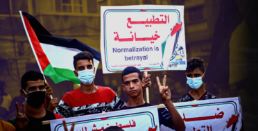 A protester holds a placard that says Normalization is betrayal during the demonstration. Palestinians protest against the Israeli normalization agreement with the UAE and Bahrain in Khan Yunis, in the southern Gaza Strip hours before the signing ceremony at the White House. (Photo by Yousef Masoud / SOPA Images/Sipa USA)(Sipa via AP Images)