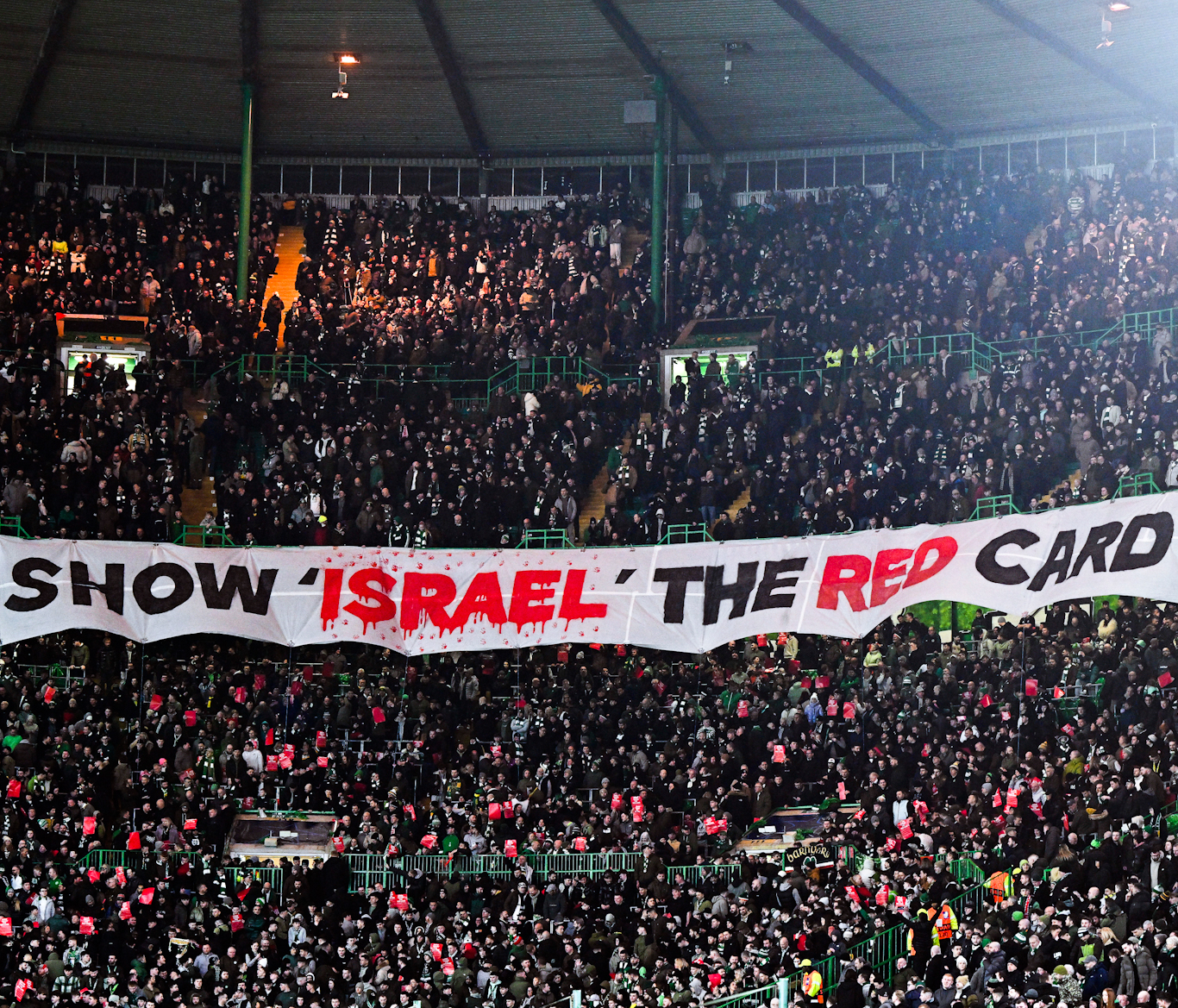 Celtic fans display a banner reading "Show Israel the red card" during the UEFA Champions League knockout match against Bayern Munich in Glasgow on February 12, 2025.