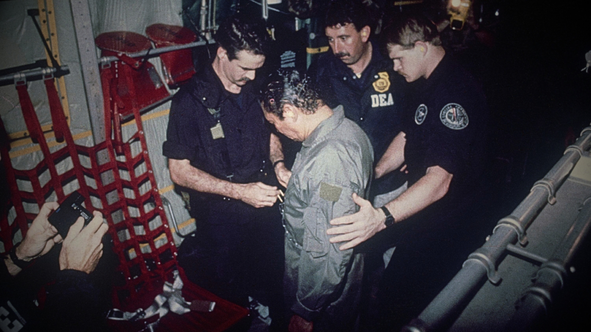 Manuel Antonio Noriega watches as U.S. Drug Enforcement Agents place chains around his waist aboard a C-130 transport plane on Jan. 4, 1990. Noriega surrendered to U.S. authorities in Panama City and was flown to Miami, Florida, where he faced drug trafficking charges. Photo | AP
